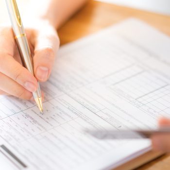 hand with pen and credit card over application form .