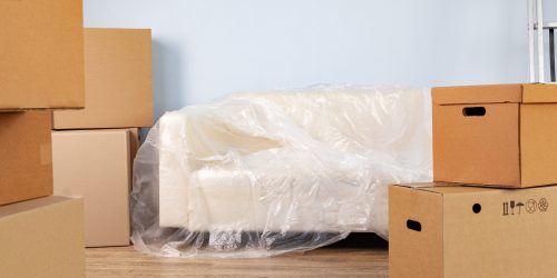 packed household stuff in boxes and packed sofa for moving