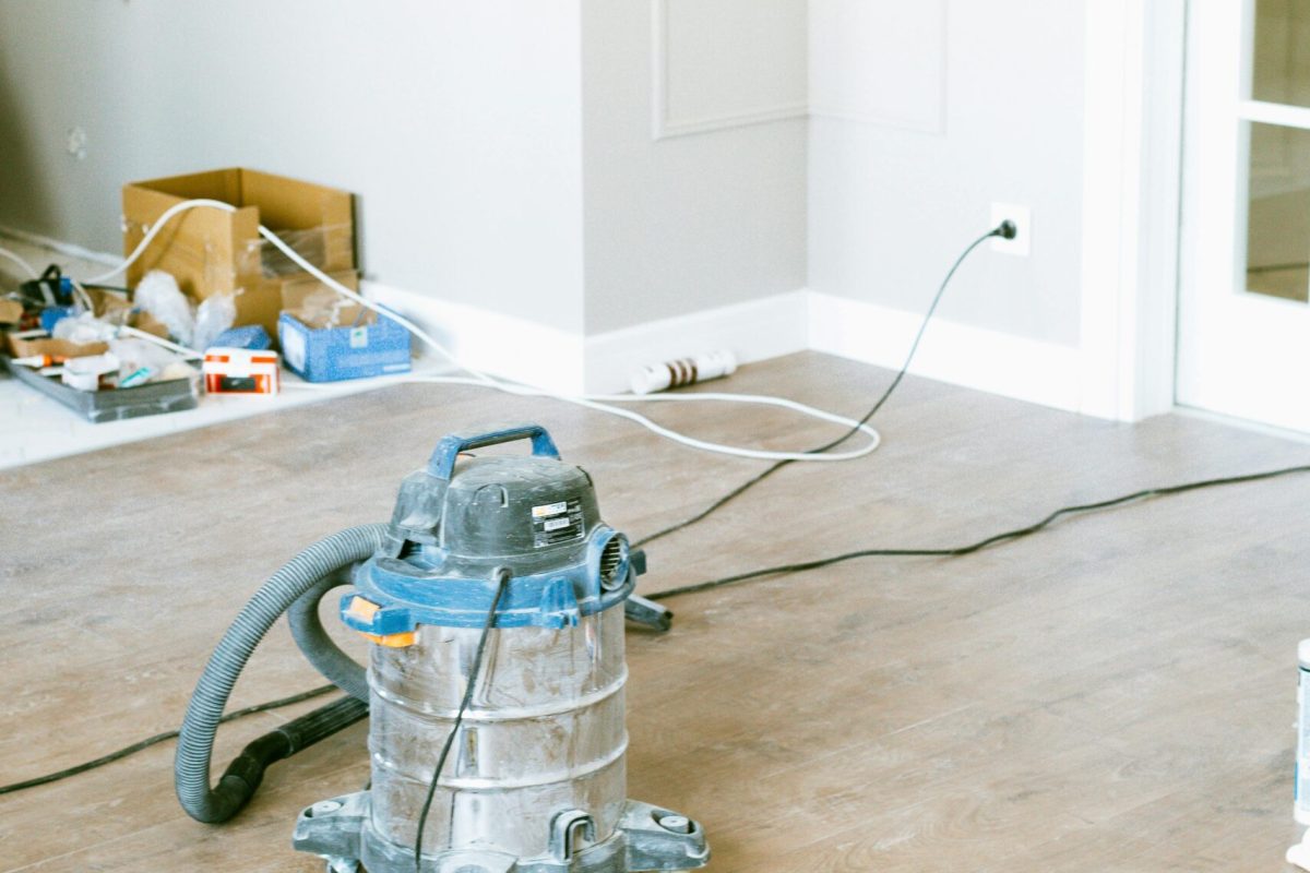 Vacuum and tools in a room undergoing renovation, showcasing home improvement.
